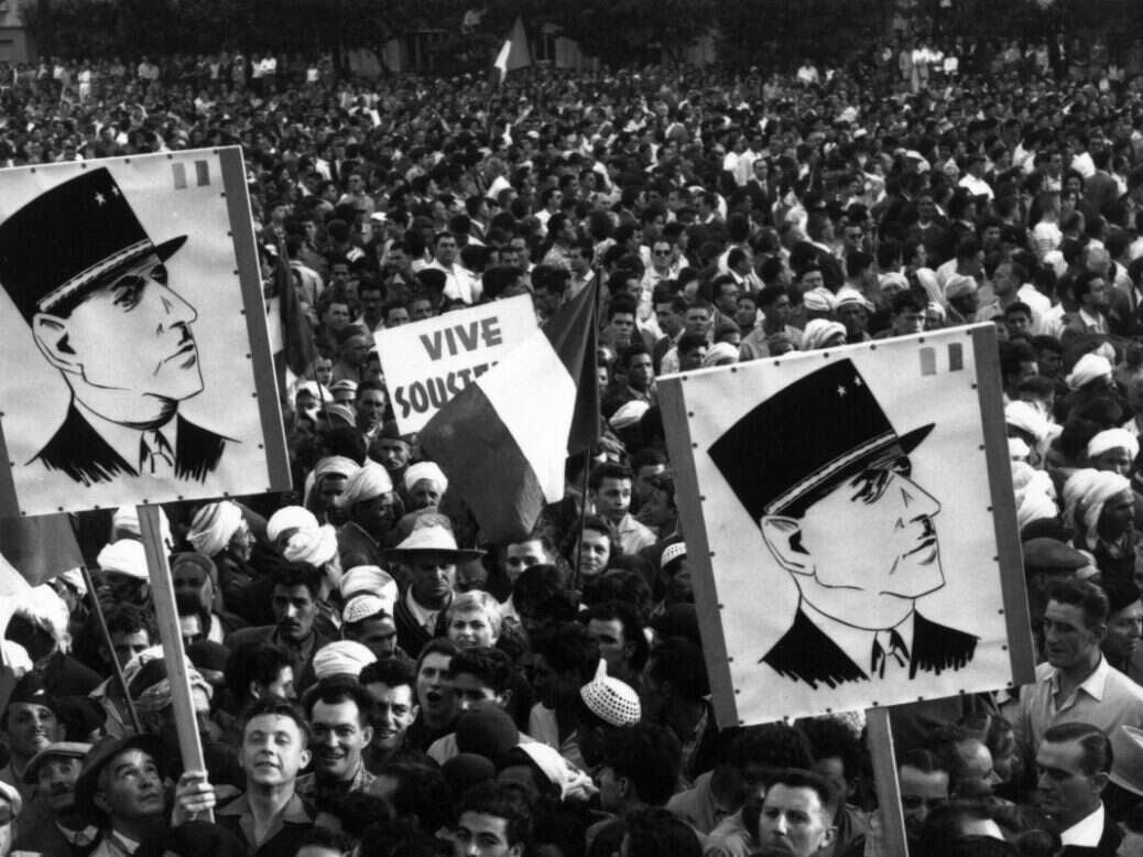 A crowd of Algerian demonstrators outside Government House, carrying Charles de Gaulle posters during the Algerian war of independence.