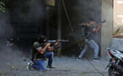 Shia fighters from Hezbollah and Amal take aim during clashes in a southern suburb of Beirut, on 14 October.