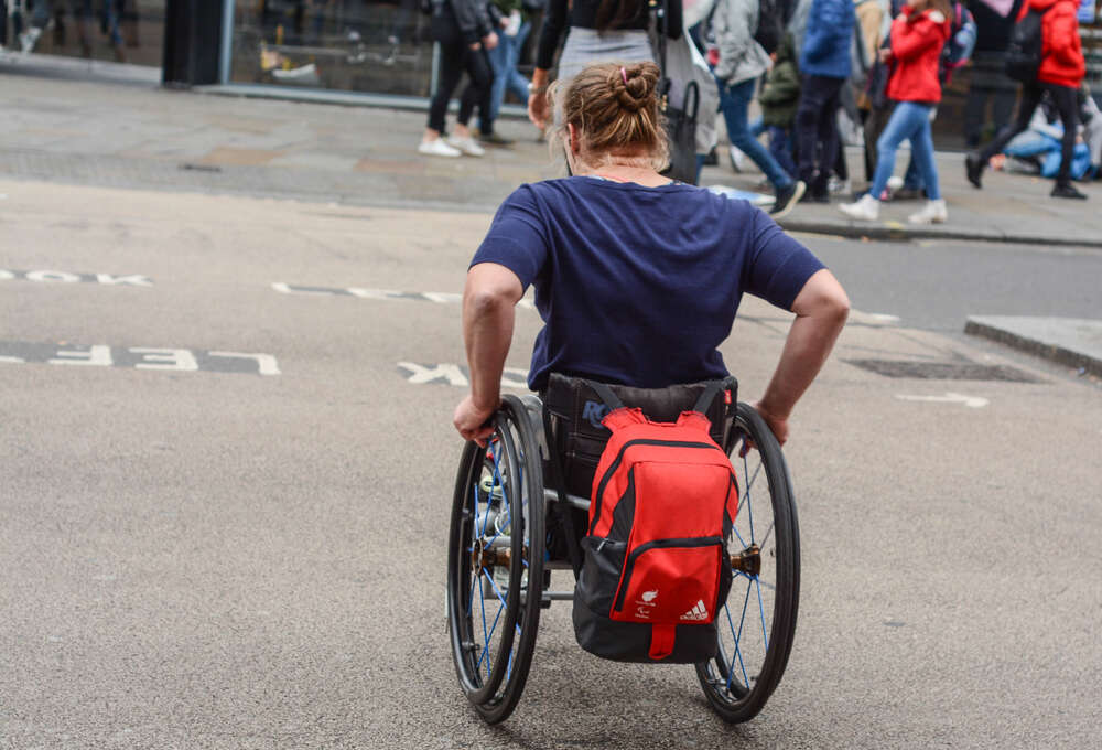 A woman in a wheelchair crossing a street in London