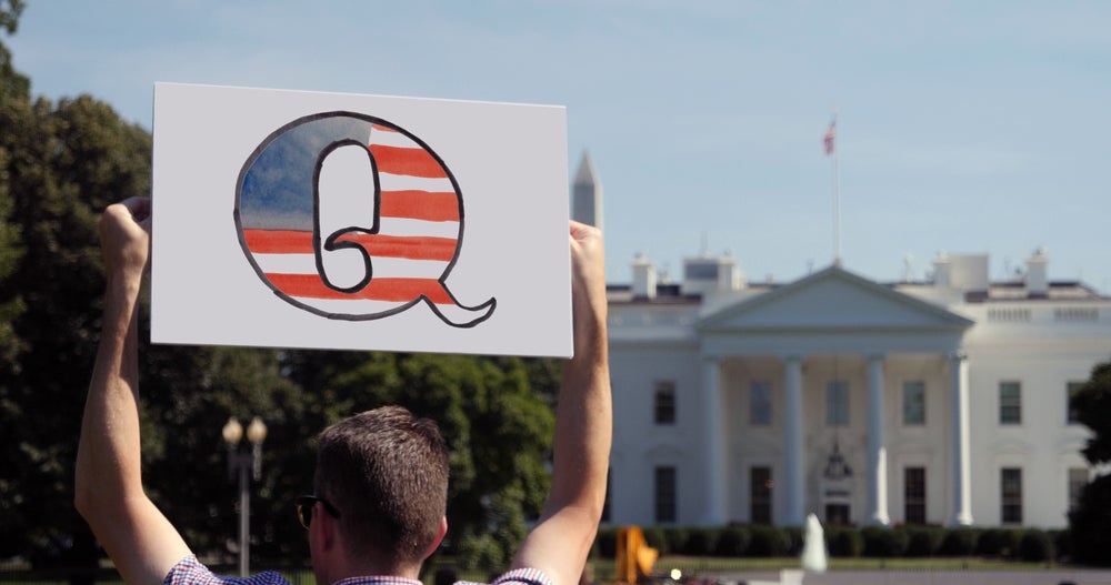QAnon supporter holding sign up outside the White House